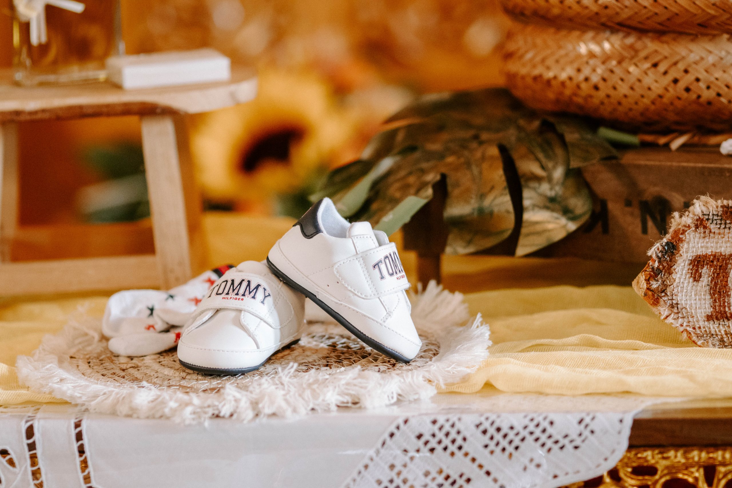 Weiße Babyschuhe auf einem festlich gedeckten Tisch
